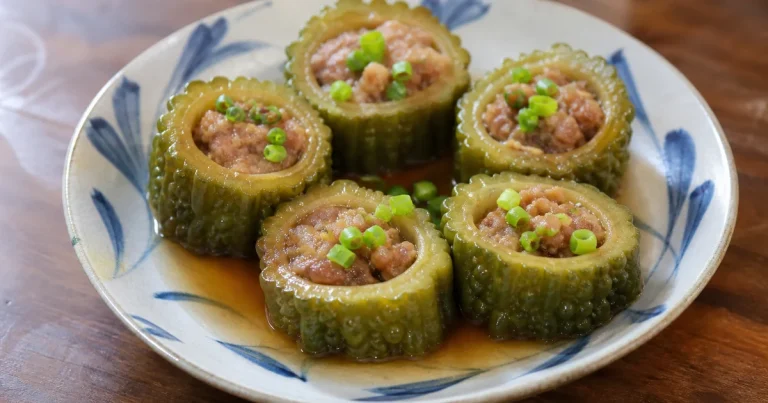 Taiwanese stuffed bitter melon with pork served on a plate, made with Okinawan goya and sprinkled with scallions.